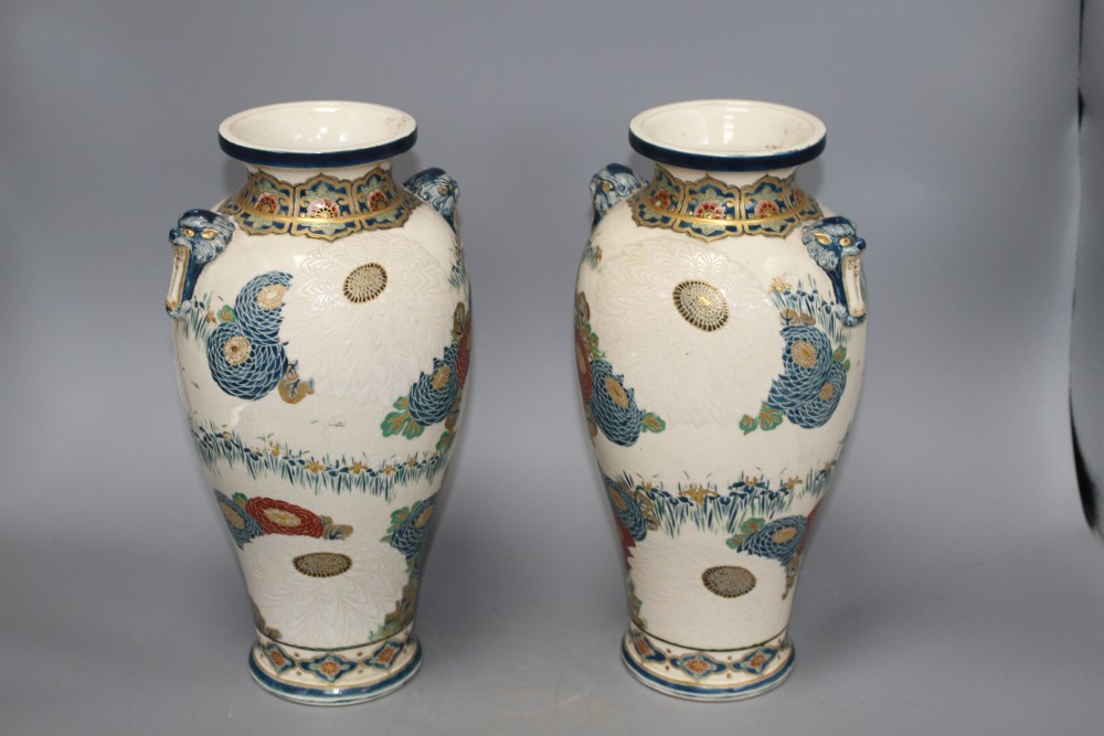 A pair of Satsuma vases, decorated with chrysanthemums, irises and storks, with beast head lug handles, height 31cm
